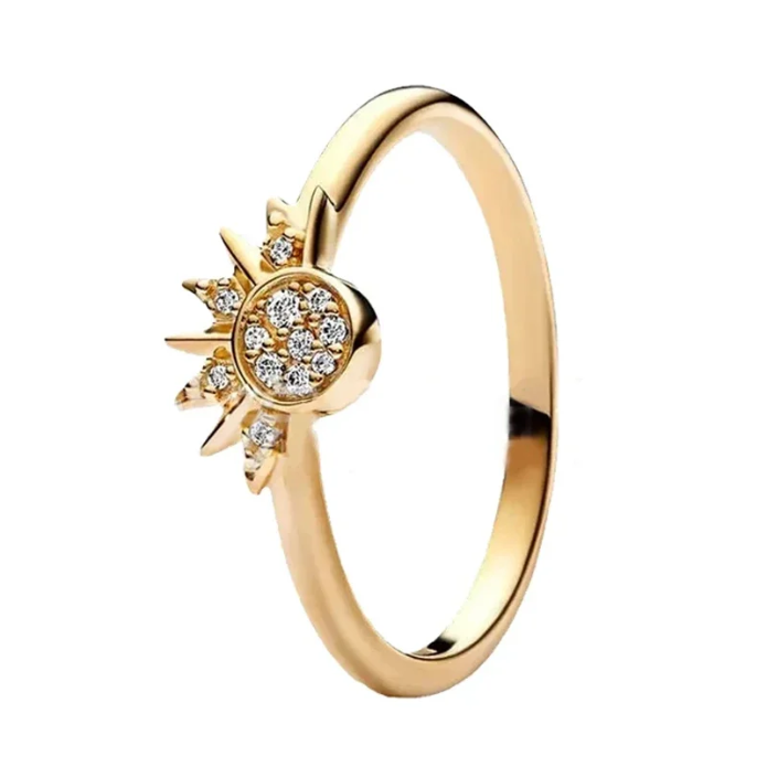 Gold ring with sun design and diamonds on a white background