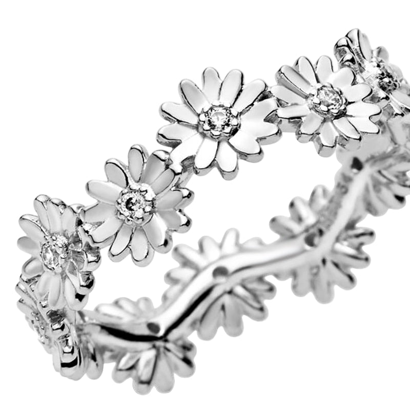 Silver floral ring with diamond-like stones on a white background