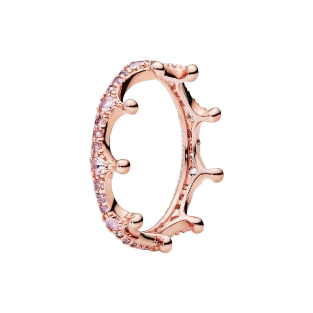 Rose gold ring with pink gemstones on a white background