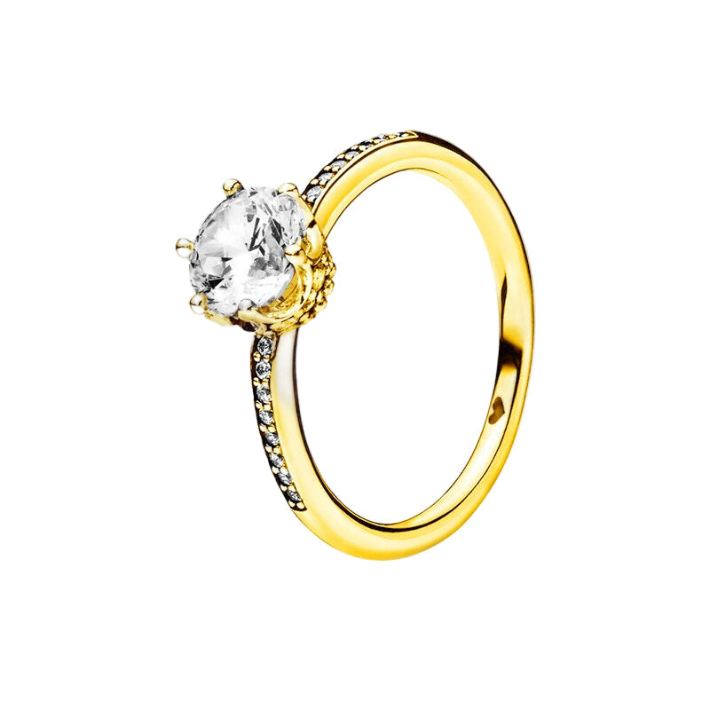 Gold ring with a clear gemstone on a white background
